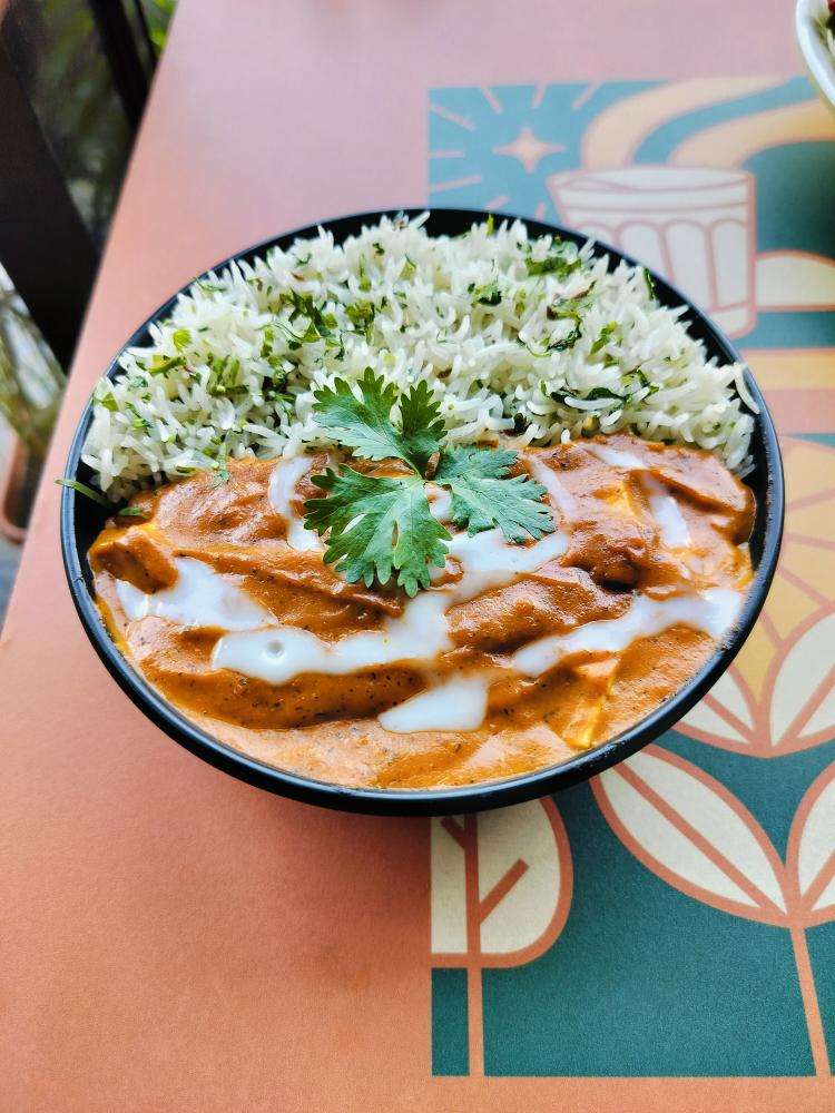 Butter Chicken with jeera rice in a bowl