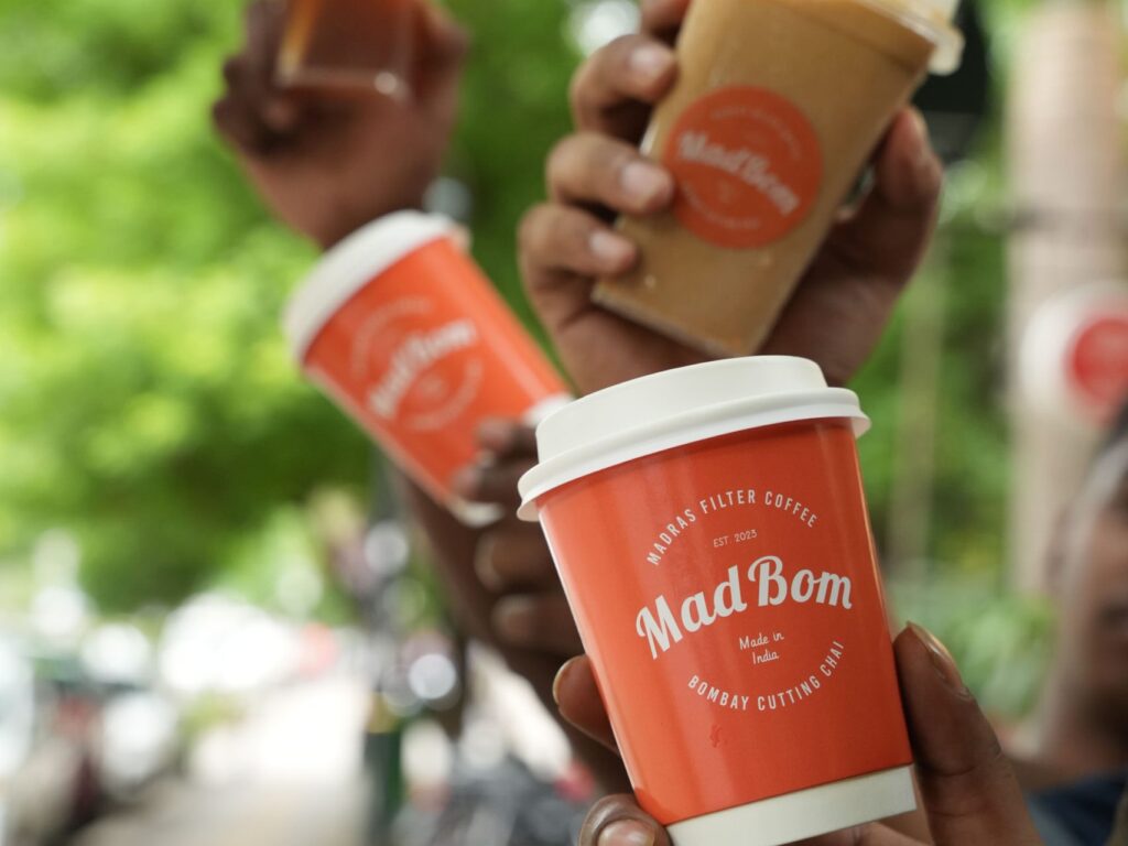Four individuals proudly display three distinct types of coffee cups, showcasing their diverse coffee preferences.